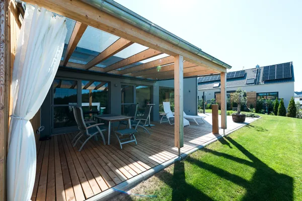 Überdachte Holzterrasse mit Schutzvorhang